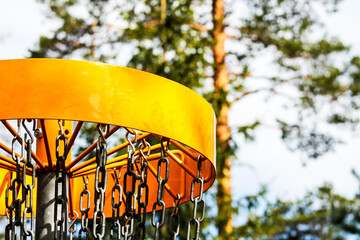 Yellow disc golf basket in the woods