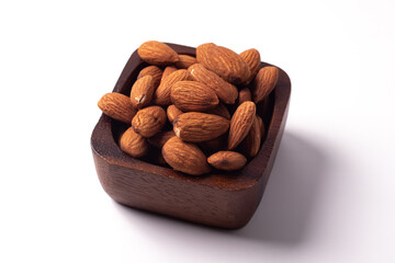 Almonds in a wooden cup on a white background