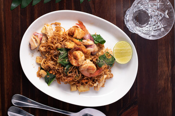 Stir fried instant noodles, stir-fry soy sauce, seafood on the wood floor