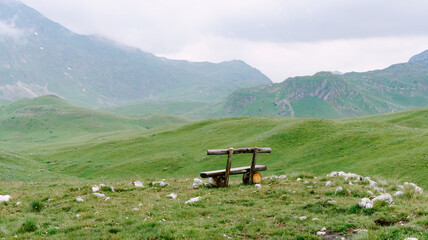 Fototapeta na wymiar A wooden bench in the mountains of Montenegro in Durmitor National Park, Sedlo Pass.