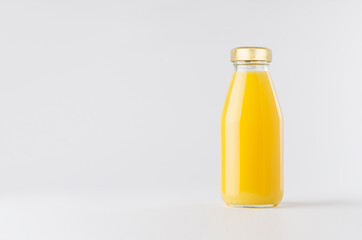 Orange yellow juice in glass bottle with gold cap mock up on white background with copy space, template for packaging, advertising, design product, branding.