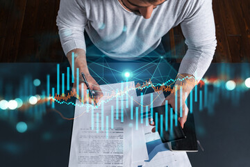 Good looking man working on investment project. Multiexposure. Forex graph Hologram.