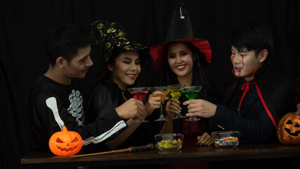 4 Young Asian teens having colorful cocktail drinks. Enjoying at Halloween party with group of friends.