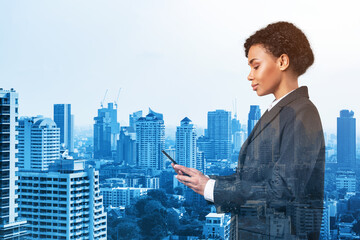 Fototapeta na wymiar Attractive black African American business woman in suit using smart phone and thinking how to tackle the problem, new career opportunities, MBA. Bangkok on background. Double exposure.