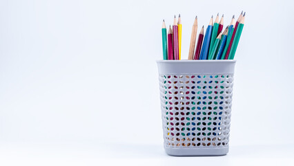 A basket of colorful pencils on a white background
