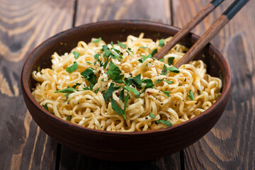 bowl of traditional Chinese noodles and chopsticks on wooden background