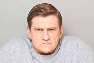 Portrait of angry disgruntled mature man with frowning face