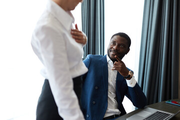 black businessman is flirting with chambermaid in hotel, blonde female doing her work, clean the...