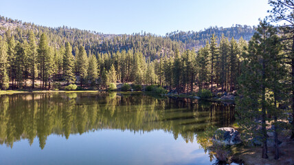 Fototapeta premium Drone photo over antelope lake beautiful blue color with tree reflections
