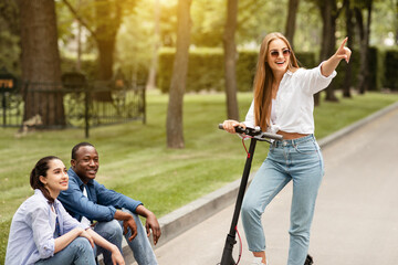 Obraz premium Girl having ride on motorized kick scooter at sunset