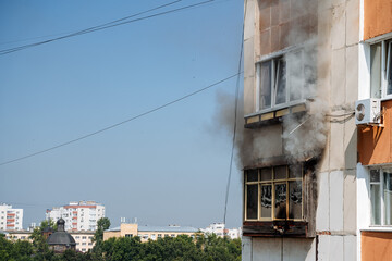 Fototapeta na wymiar fire on the balcony of a multi-storey building, black clouds of smoke, apartment smoke, extinguishing fire in a residential building, fire escape, emergency, fire, open fire, house fire
