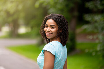 Portrait of pretty African American girl posing at park in summertime