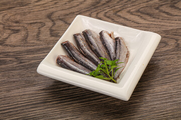 Anchovies in the bowl served basil leaves