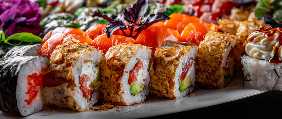 set of sushi roll with salmon, avocado, cream cheese, cucumber, rice, caviar, eel, tuna in plate on black wooden table background