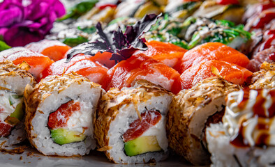 set of sushi roll with salmon, avocado, cream cheese, cucumber, rice, caviar, eel, tuna in plate on black wooden table background