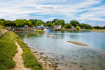 A view down the banks of the River Ouse towards the village of Piddinghoe, UK in summer © Nicola