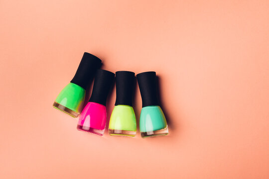 Neon nail polish bottles on a color background.
