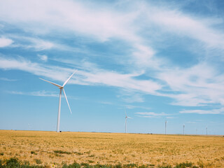 Wind turbines on the grassy plains out in the country in central Kansas