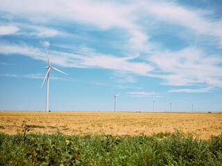 Wind turbines on the grassy plains out in the country in central Kansas