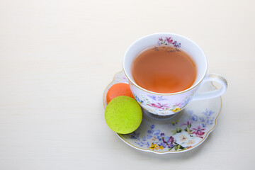 Colorful macaroons and a cup of tea. Afternoon tea break, traditional french sweet.