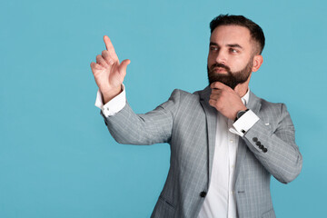 Office worker in formal suit selecting something on transparent screen over blue background, free space
