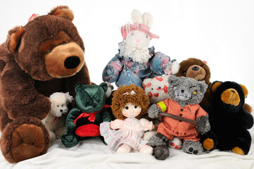 Raggedy Ann with stuffed animals on the bed with one nasty teddybear