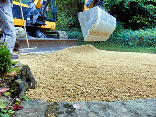 Old drive being covered with new castings (sand and gravel)