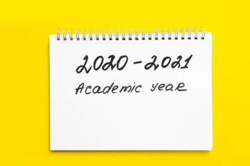 2020 - 2021 academic year. The inscription in a white notebook with a spiral, on a yellow background. Back to school. Concept of the new school year and return to school.