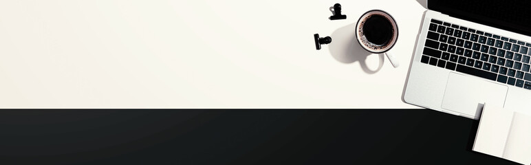 Laptop computer with a notebook and a cup of coffee