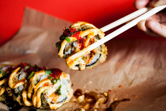 Savory tempura salmon sushi roll with sauce, roe, scallion
