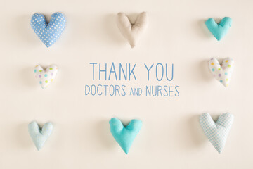 Thank You Doctors and Nurses message with blue heart cushions on a white paper background