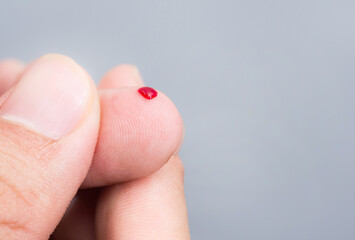 Blood drop on fingertip prepare for checking the glucose level with a glucometer for examining...