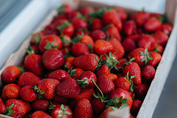 Ripe fresh strawberries close-up in a container for sale. Healthy diet