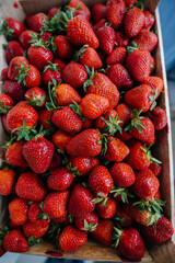 Ripe fresh strawberries close-up in a container for sale. Healthy diet