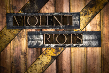 Violent Riots text formed with real authentic typeset letters on vintage textured silver grunge...