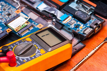 Repair an electronic device using a multimeter by measuring the voltage of the laptop Board using a digital multimeter.