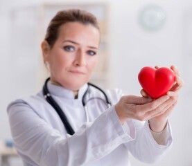 Cardiologist with red heart in medical concept