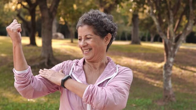 Lovely Retired black brazilian woman with sportswear showing arms and healthy physical shape. Outside in park and woods. Overcome, healthy, fitness, freshness concept.