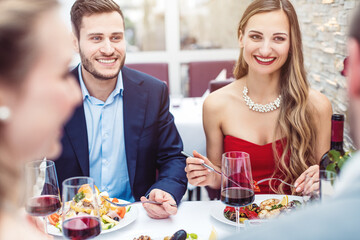 Two cheerful couples chatting in nice restaurant