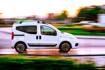 A car on the street. Moving car. White car in a blurred city scene.