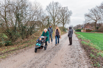 Multi-generational family walking on footpath between fields