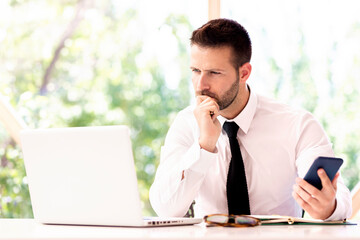 Handsome businessman working on laptop at office desk