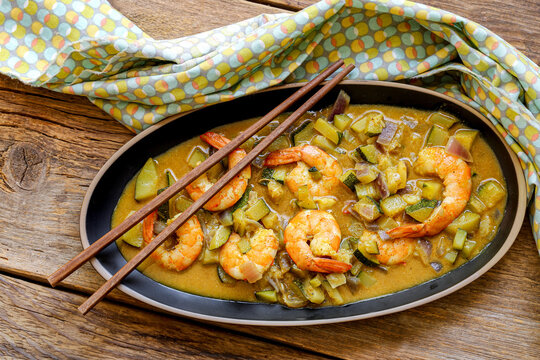 cuisine tha&iuml; : gambas au lait de coco , curry, d&eacute;s de courgettes et oignons rouges avec du riz 