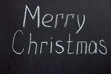 The inscription on a dark board "Merry Christmas". Congratulations on a religious holiday