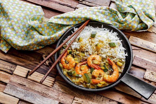 cuisine tha&iuml; : gambas au lait de coco , curry, d&eacute;s de courgettes et oignons rouges avec du riz 