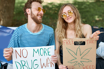 legalize marijuana agitation, manifestation. two caucasian young adults holding banners and...