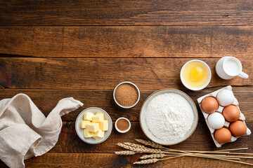 Ingredients for baking on a rustic wooden background. Flour, eggs, butter, sugar and other ingredients for baking a cake, sweet bread pastry or cookies