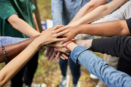 close-up photo of diverse people's hands gathered together, african american and caucasian people as one union. various ethnicities are friends all over the world