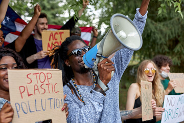 diverse environmental activists hold colourful placards and chant slogans during a demonstration to...