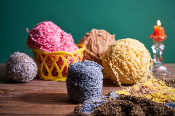 Balls of yarn and candle on wooden table